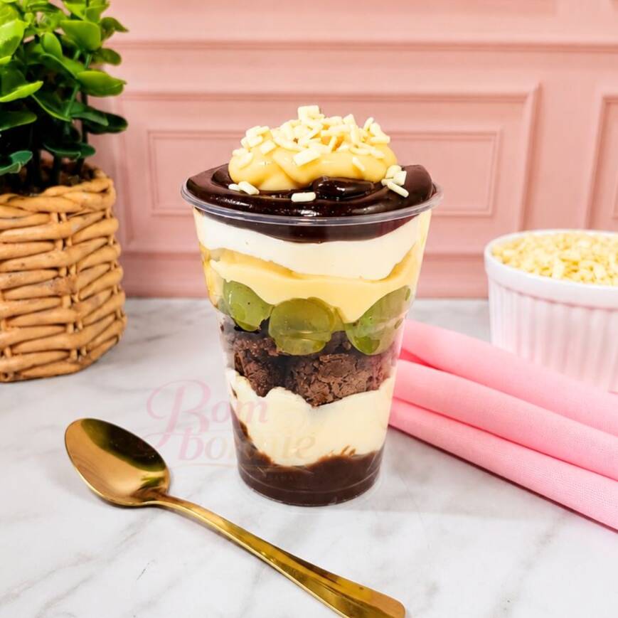 Tenha a felicidade na palma da mão com nosso irresistível Copo da Felicidade Surpresa Uva! Em um copo de aproximadamente 250g, você vai se deliciar com a combinação perfeita de mousse de Ninho, brigadeiro cremoso branco, brigadeiro de chocolate 50%, uvas frescas e brownie. Experimente essa sensação única e encante-se! . Serve até 1 pessoa. Peso aprox.: 250g