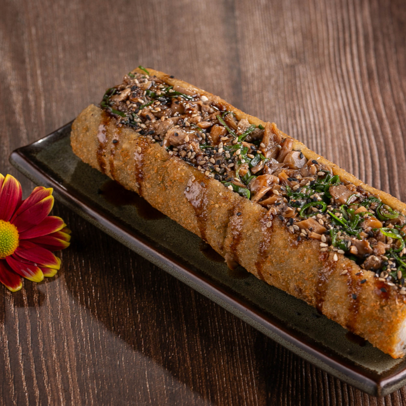 Hot empanado cortado ao meio com recheio de cream cheese, shimeji, finalizado com molho de pimenta, cebolinha e gergelim.