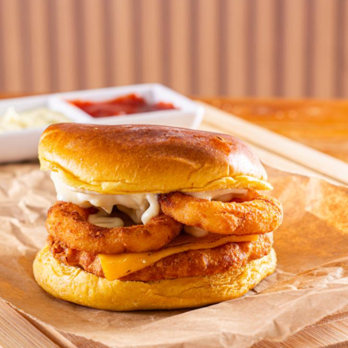 Pão Brioche amanteigado, Frango empanado, queijo cheddar, cebola empanada, barbecue e maionese especial.