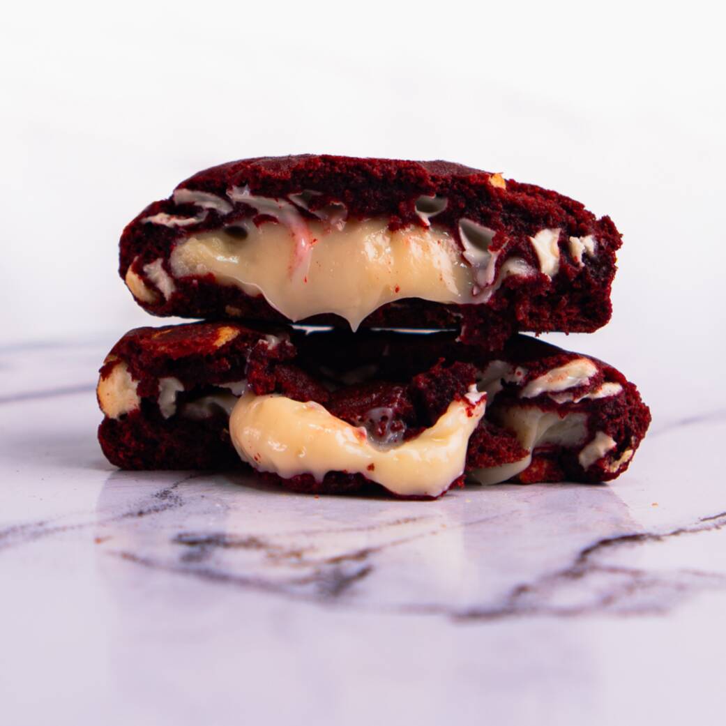 Nosso cookie de Red Velvet é feito com massa de cacau, recheado com um delicioso brigadeiro de cream cheese e finalizado com gotas de chocolate nobre branco.