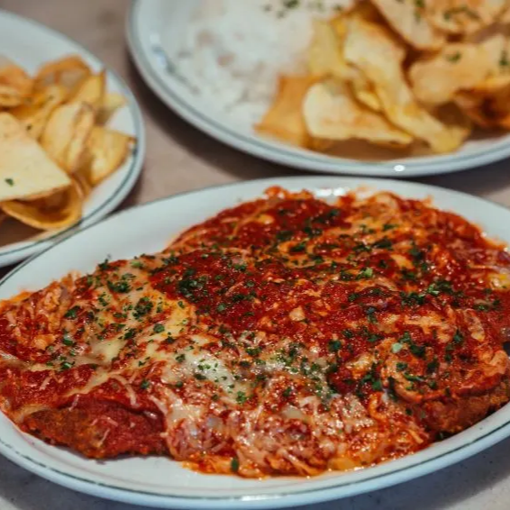 Duas marmitas recheadas com arroz, feijão, fritas e filé a parmegiana ou bife a parmegiana