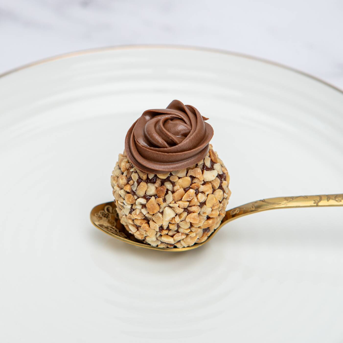 brigadeiro de cacau recheado com brownie, finalizado com amendoim triturados e torrados. E avelã para dar o toque final.