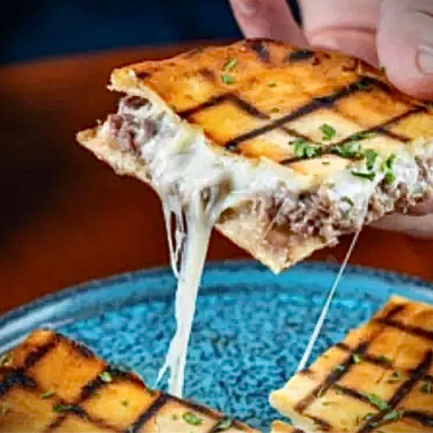 Pão sírio da casa, kafta grelhada com temperos árabes e coberto com bastante mussarela.