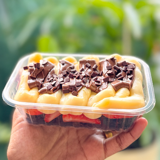 O escondidinho de brownie é feito com uma camada de brownie, uma camada de morangos frescos, de recheio temos o recheio de Ninho e rastros de Nutella finalizado com granulado de chocolate.