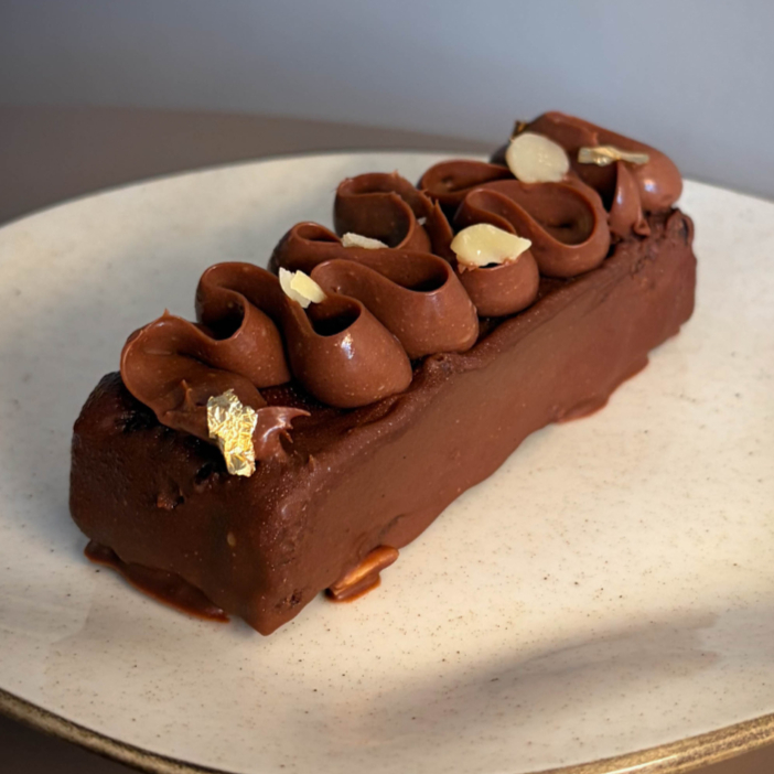 Fatia de Brownie mergulhado em chocolate com amêndoas, e cobertura de Ganache feito com Chocolate nobre ao leite e Caramelo. Finalizado com amêndoas in natura torradas. Bem chocolatudo, gosto intenso mas leve de chocolate ao leite.