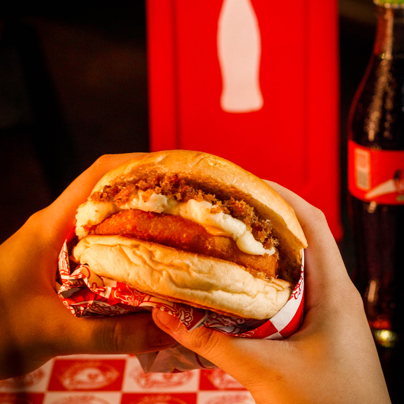 Pão amanteigado selado na chapa, disco de frango Seara Supreme, american cheese, Catupiry e farofa de bacon.
