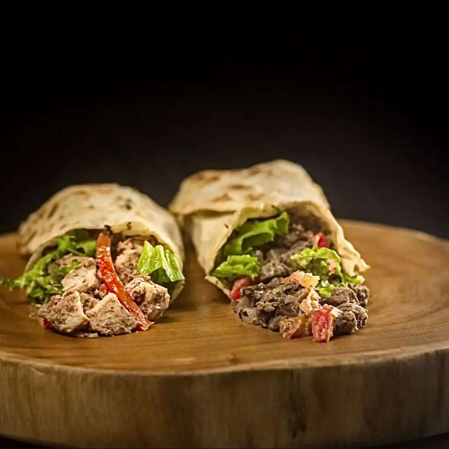 Pão sírio de 25cm recheado com uma mistura de carne e frango, alface fresco, tomate maduro e cebola temperada. Acompanha o molho de alho caseiro.