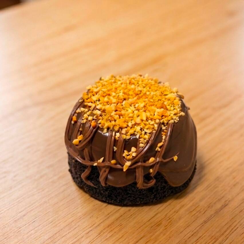 Delicioso bolo de chocolate, com cobertura de brigadeiro trufado nobre e finalizado com Nutella e amendoim triturado.