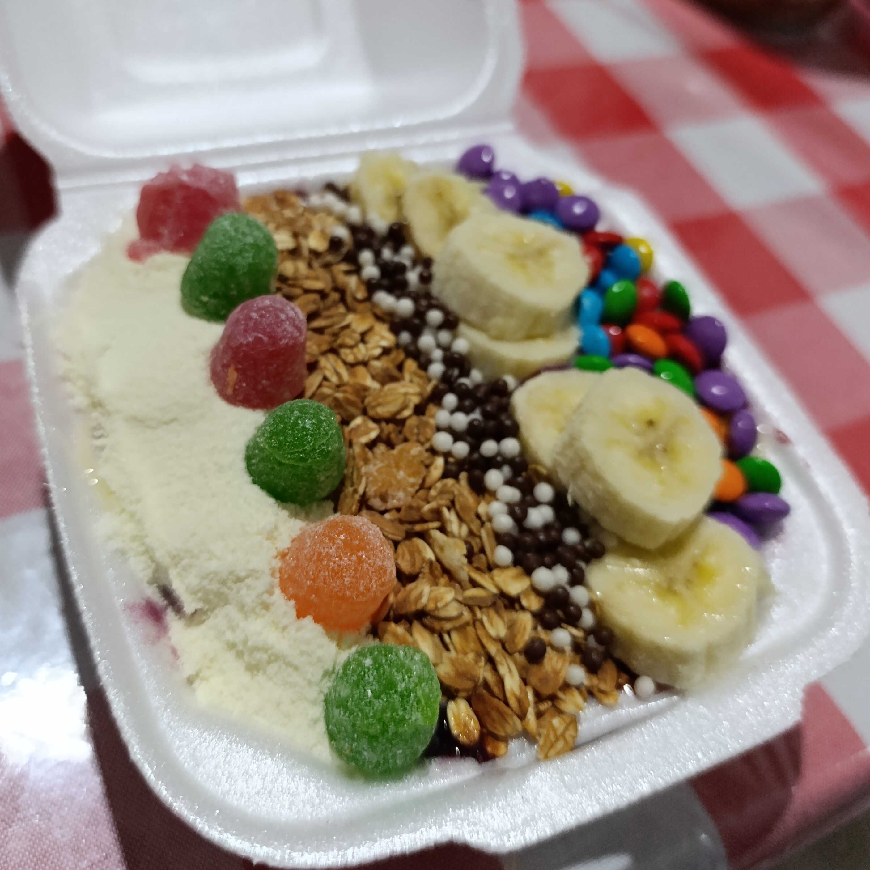 Acompanha leite em pó, granola, banana, leite condensado, confetes, bolinhas de chocolate e jujuba.
