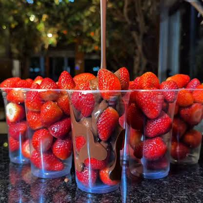 Um delicioso copo com morangos e chocolate ao leite.