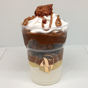 Camadas de mousse de leite em pó, creme de leite em pó, creme de avelã, pedaços de brownie, creme de chocolate e chantilly para finalizar!