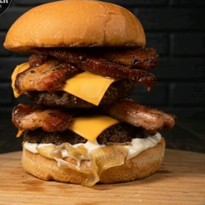 Pão Assado na Chapa, 2 Blends de 150g, 2X de Bacon, Fatias de Queijo Cheddar, Cebola Caramelizada e a Nossa Maionese Artesanal