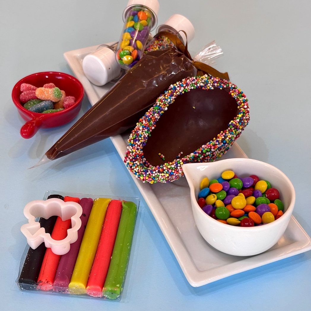 Nosso confeiteiro vai em uma Linda caixa infantil, uma casca de 150G, uma bisnaga de brigadeiro, 3 tubetes de confeitos, bala fini dentro da casca e uma Massinha de modelar.