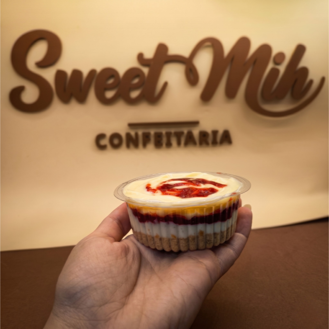 Base de biscoito harmonizando com a suavidade do nosso delicioso Creme de Ninho com uma camada de Geleia Caseira finalizado com brigadeiro de ninho. Cada colherada revela camadas de pura perfeição. Uma experiência inesquecível para o paladar. (Aprox. 120gr)