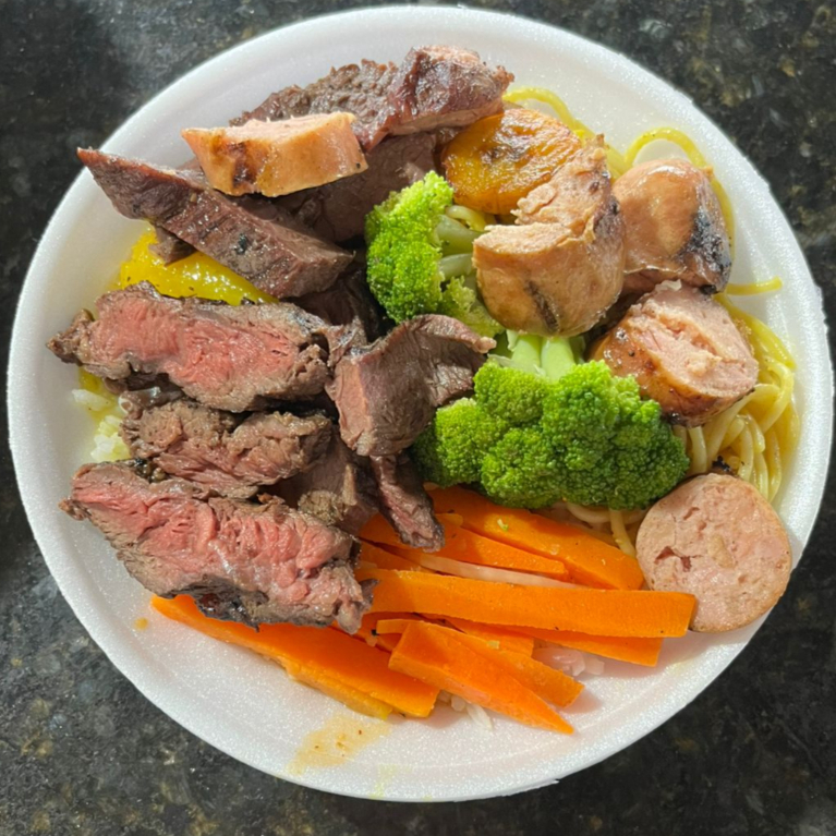Arroz branco , feijão de caldo, legumes, macarrão, banana frita, mandioca cozida e churrasco. ACOMPANHA MIX DE SALADA Obs. : Na falta de um dos acompanhamentos será substituído por algum item do cardápio do dia.