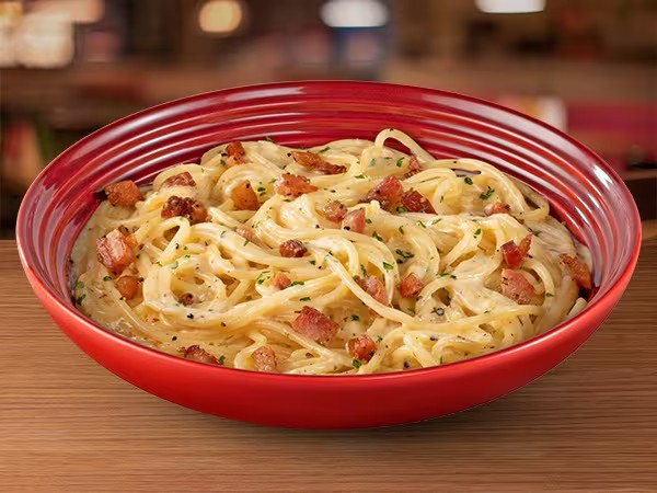 Spaghetti servido com um cremoso molho de parmesão Faixa Azul, pancetta e gema de ovo.