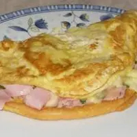 Omelete feita com 2 ovos, bacon, presunto e queijo, acompanha arroz, feijão, farofa, salada, fritas ou legumes.