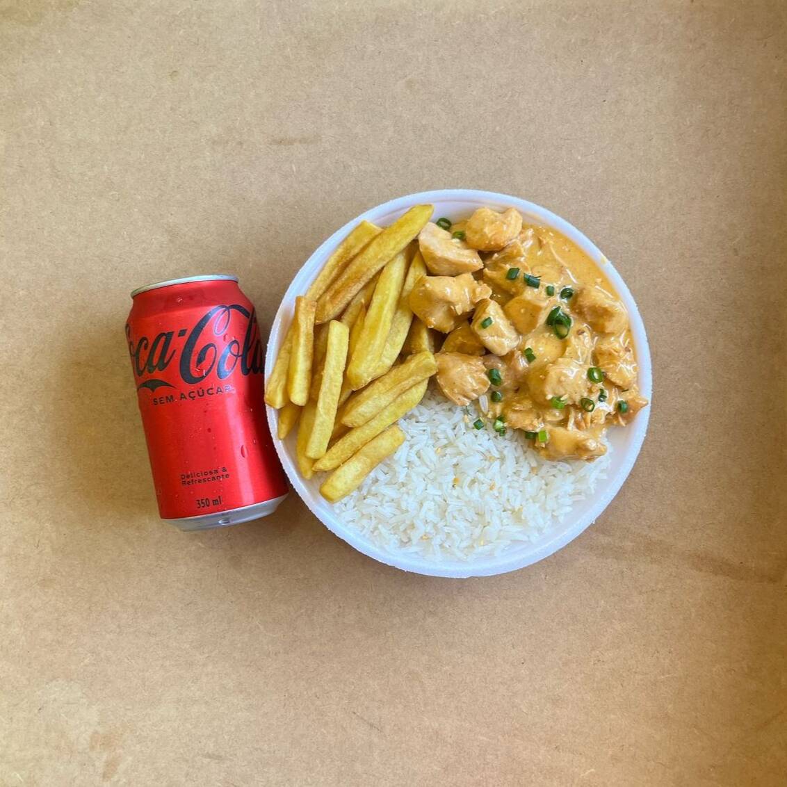 Marmita com delicioso filé de frango ao molho estrogonofe acompanhado de arroz branco e batatas fritas.. Acompanha refrigerante Coca Cola lata Zero sem açúcar 350ml bem gelada. Marmita indicada para 01 pessoa.