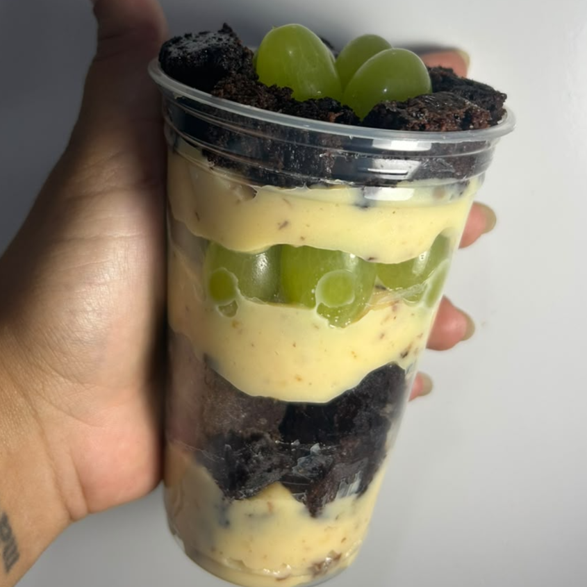Deliciosos pedaços de brownie de chocolate 50% cacau mergulhados em um creme delicioso de ninho com uma generosa camada de uvas frescas.