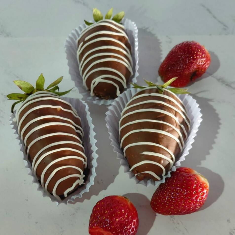 uma coxinha maravilhosa de morango recheada com uma massa cremosa de recheio de brigadeiro branco e coberta de chocolate blend Harald, sabor irresistível !