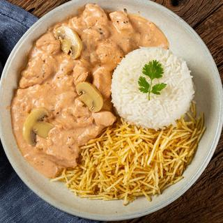 Um prato delicioso que combina pedaços de frango macios e suculentos em um molho cremoso, acompanhado com arroz soltinho e uma batata palha bem crocante