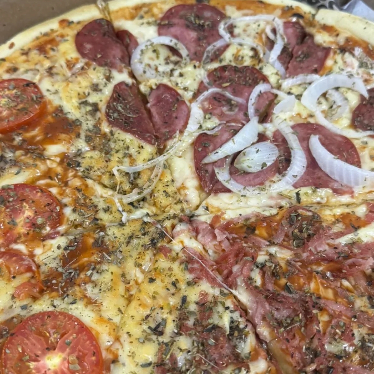 Molho de tomate, mussarela, calabresa, presunto, cebola, azeitona, orégano.