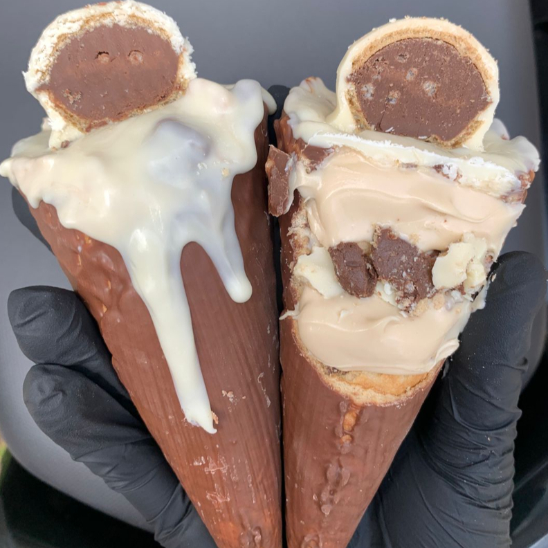 Cone banhado no chocolate ao leite recheado com creme bueno, finalizado com chocolate branco e meio ouro branco e bombom ouro branco