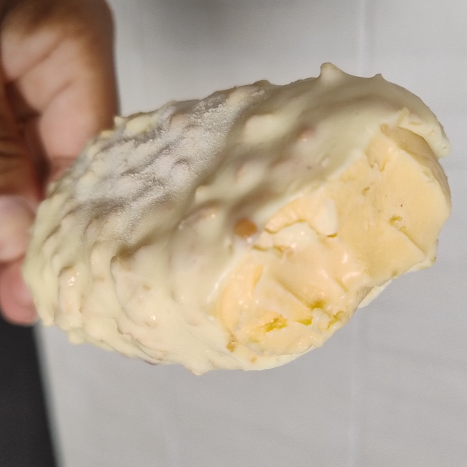 Delicioso creme com base de baunilha envolto no chocolate branco com crocante de castanha de xerem