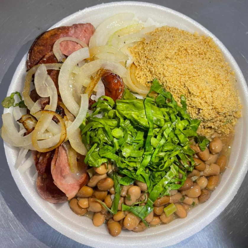 Linguiça calabresa refogada com cebola, acompanhada de arroz, feijão, farofa e couve.
