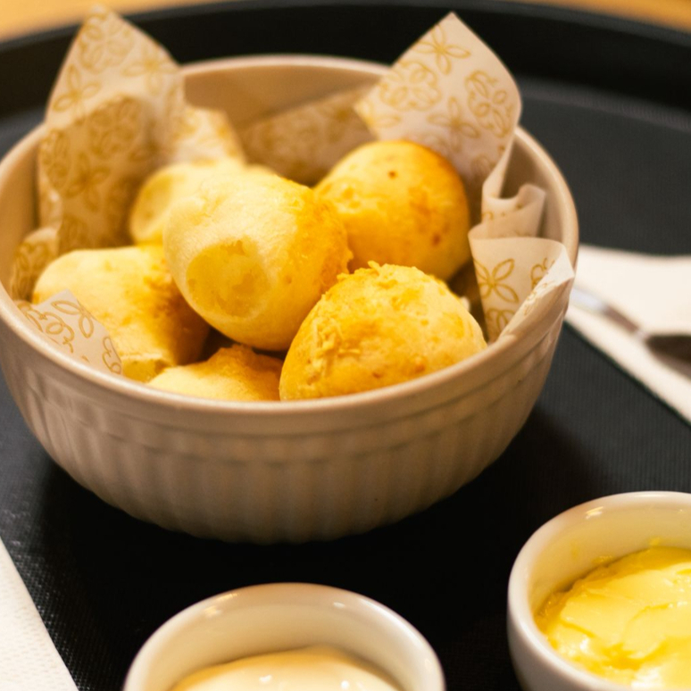 6 unidades de mini pão de queijo feitos na casa com queijo canastra e parmesão. Dois acompanhamento à escolha.