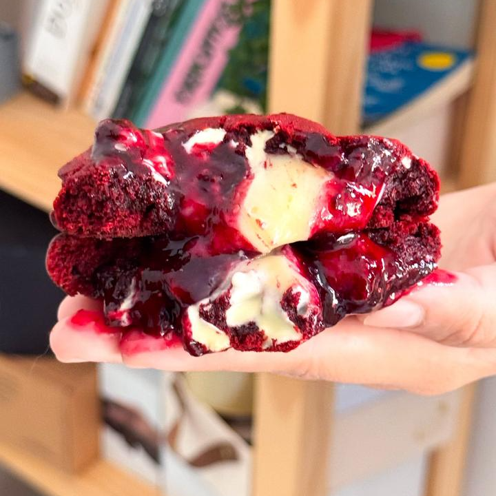 Cookie de cacau com toque de baunilha e corante vermelho, recheado com brigadeiro de cream cheese e geleia artesanal de frutas vermelhas. Crocante por fora, macio por dentro e cheio de sabor. 110gr
