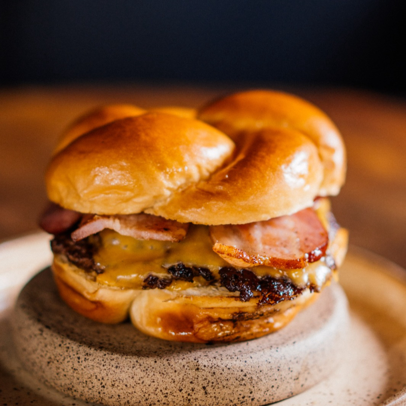 Hambúrguer de 120 grs Esmagado na Chapa / American Cheese / Bacon Grelhado / Finalizado em Nosso Exclusivo Pão de Brioche Raw / Atenção Item Servido Apenas Bem Passado.