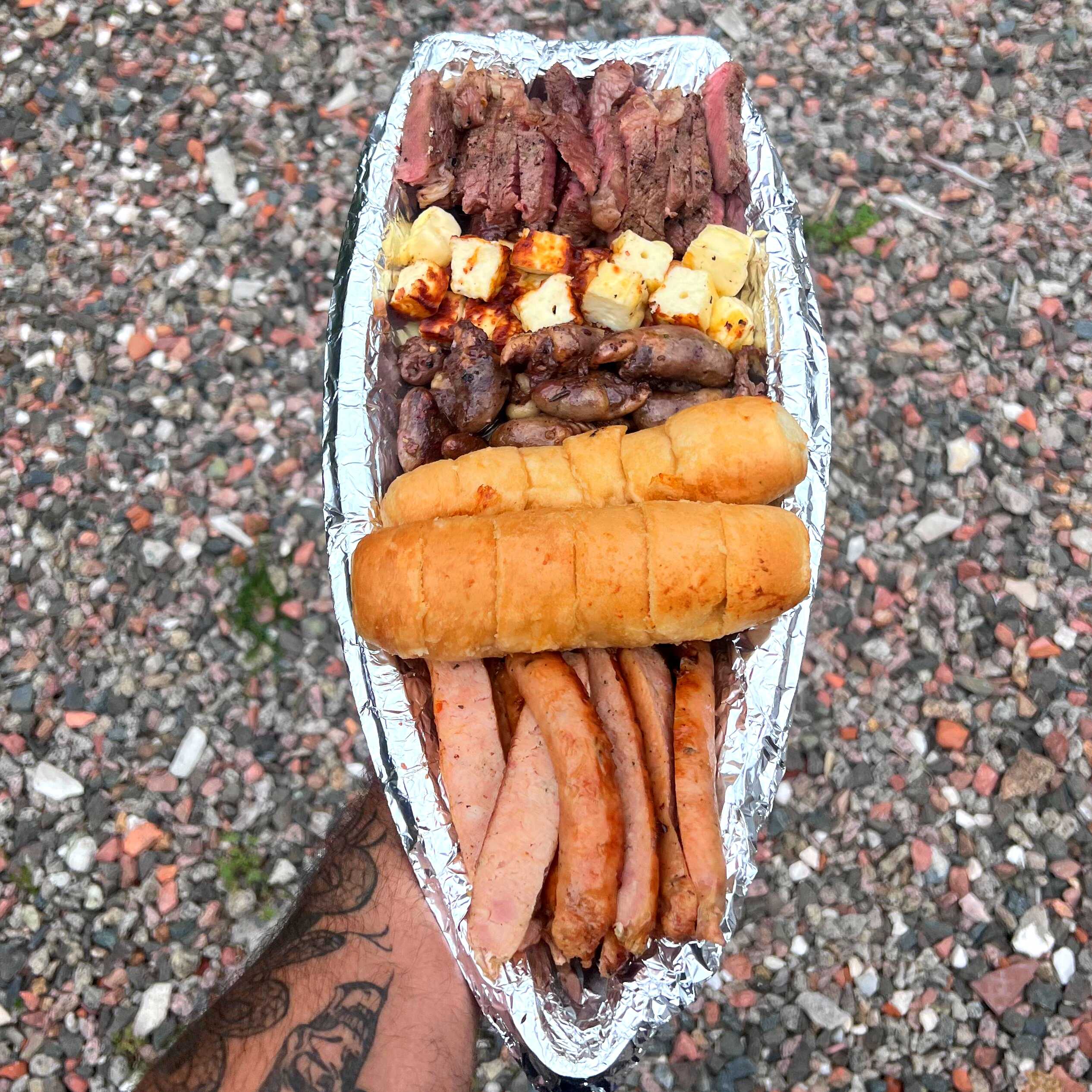 Barca composta por: 300g de contra‑filé prime suculento e macio, 300g de linguiça artesanal, 300 g de coração de frango temperado, 2 pães de alho, farofa crocante e salada fresca como acompanhamento.