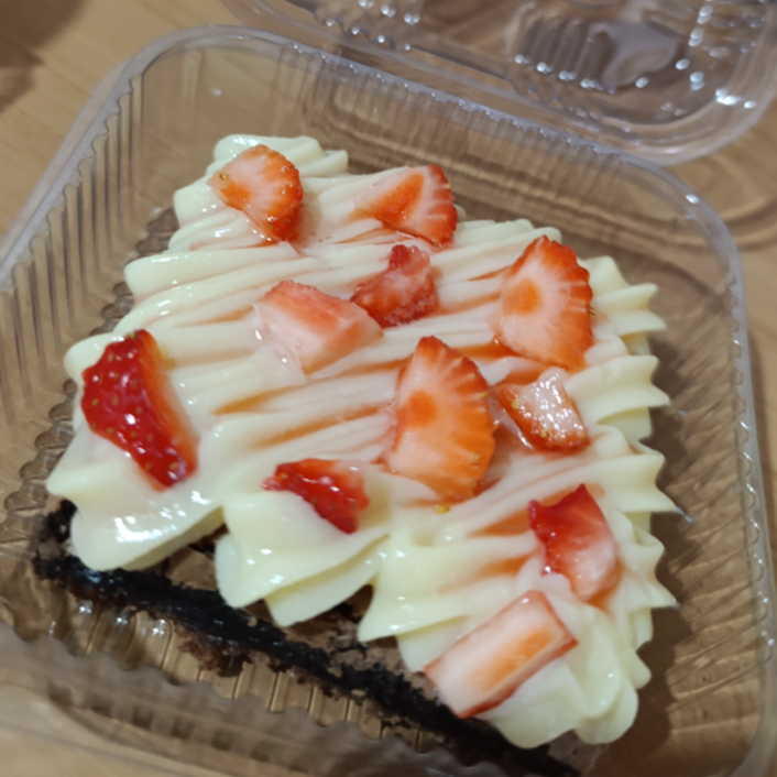 Brownie de chocolate com cobertura de chocolate branco com geleia de morango artesanal e pedaços de morango por cima