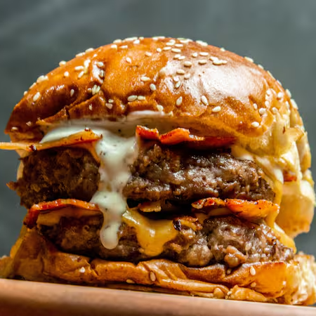 Duas carnes suculentas de 140g, queijo provolone derretido, quatro fatias de bacon crocante e molho de bacon no pão brioche. O lanche perfeito para os amantes de bacon e sabores intensos!