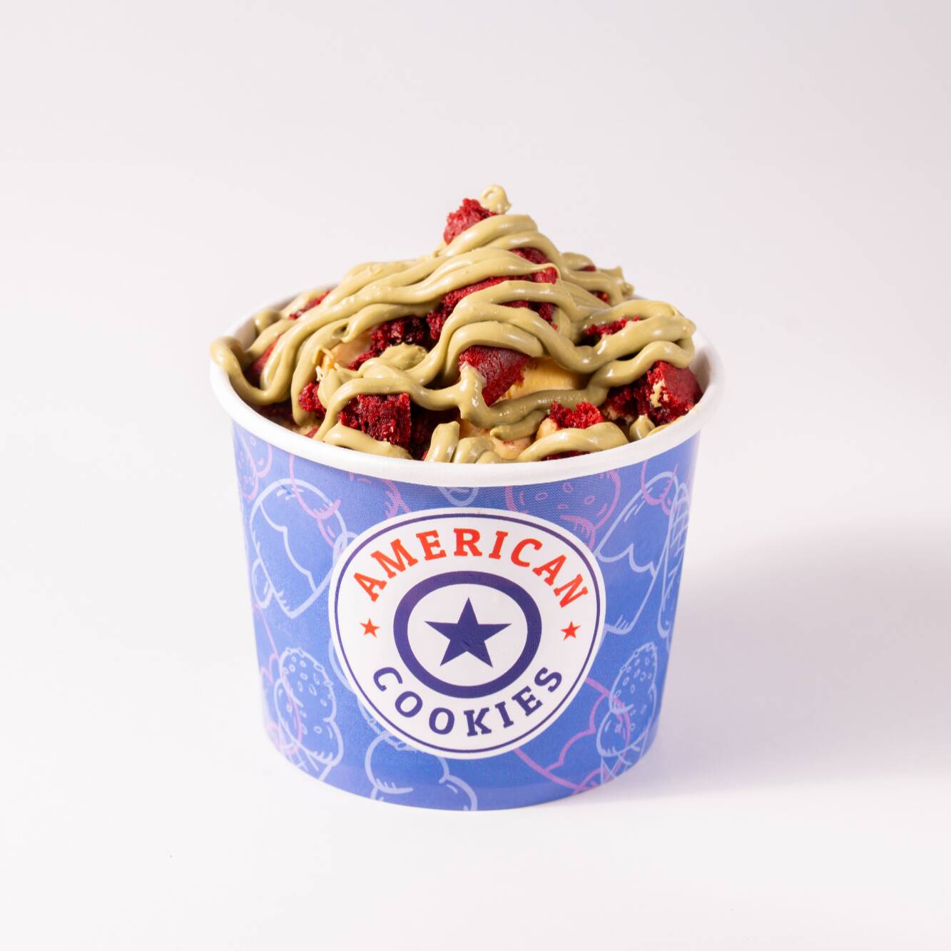 Sorvete cremoso com pedaços de
cookie clássico red velvet e finalização
com creme de pistache