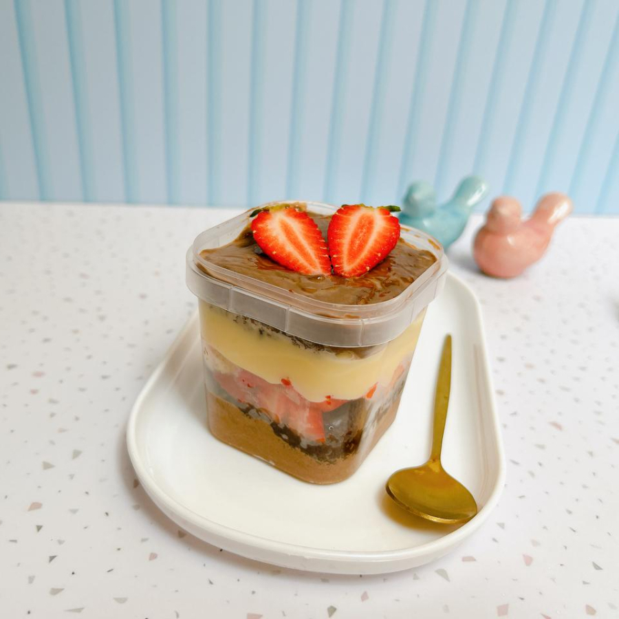 Bolo no pote com massa de chocolate molhadinha, camadas de brigadeiro de Ninho, brigadeiro de chocolate e morangos frescos.