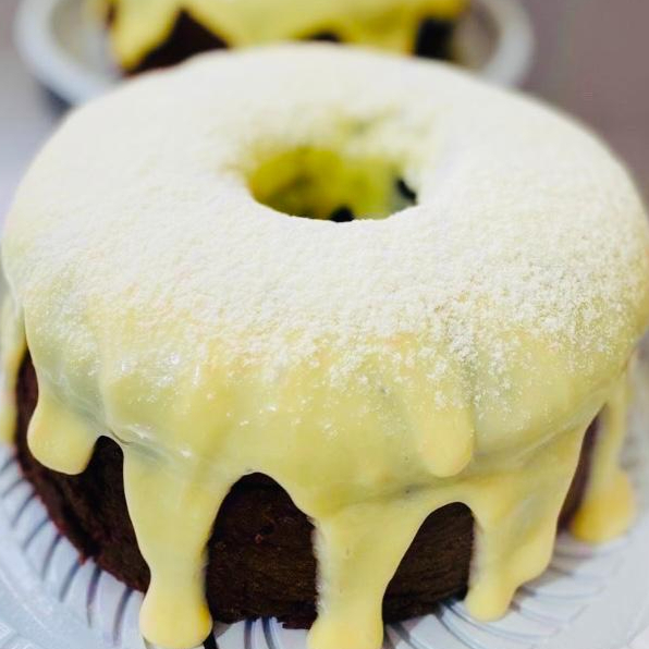 Massa de chocolate com cobertura de leite ninho, com leite polvilhado em cima