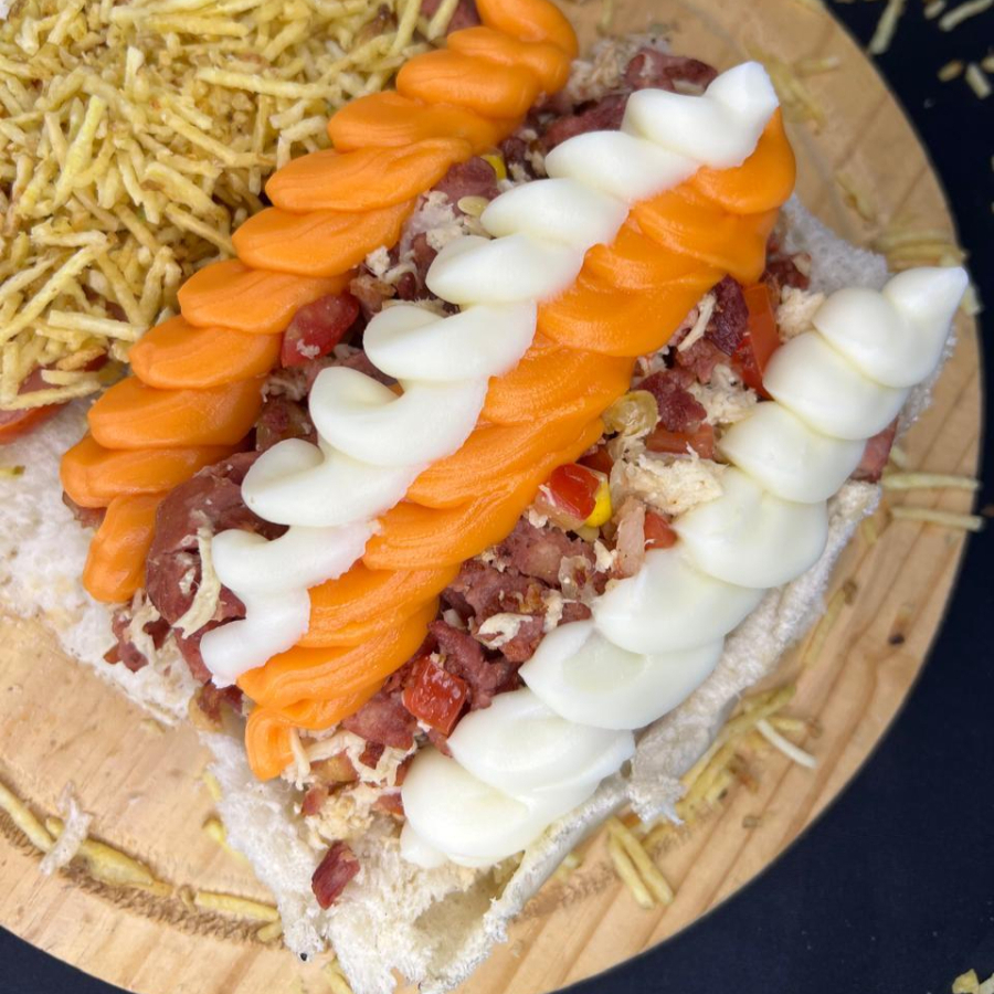 Pão de 22cm, 2 vinas, bacon, frango, calabresa, cheddar e catupiry, cebola, milho, tomate, maionese, ketchup e batata palha.
