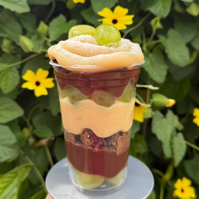 O Copo da Felicidade de Uvas é uma combinação irresistível de sabores e texturas! Camadas de uvas frescas e suculentas se unem ao creme de chocolate aveludado e, ao delicado creme de Ninho e aos pedaços macios de Brownie, criando uma explosão de sabor a cada colherada. O contraste entre o azedinho da fruta, a cremosidade dos recheios e o toque intenso do brownie torna essa sobremesa simplesmente inesquecível!