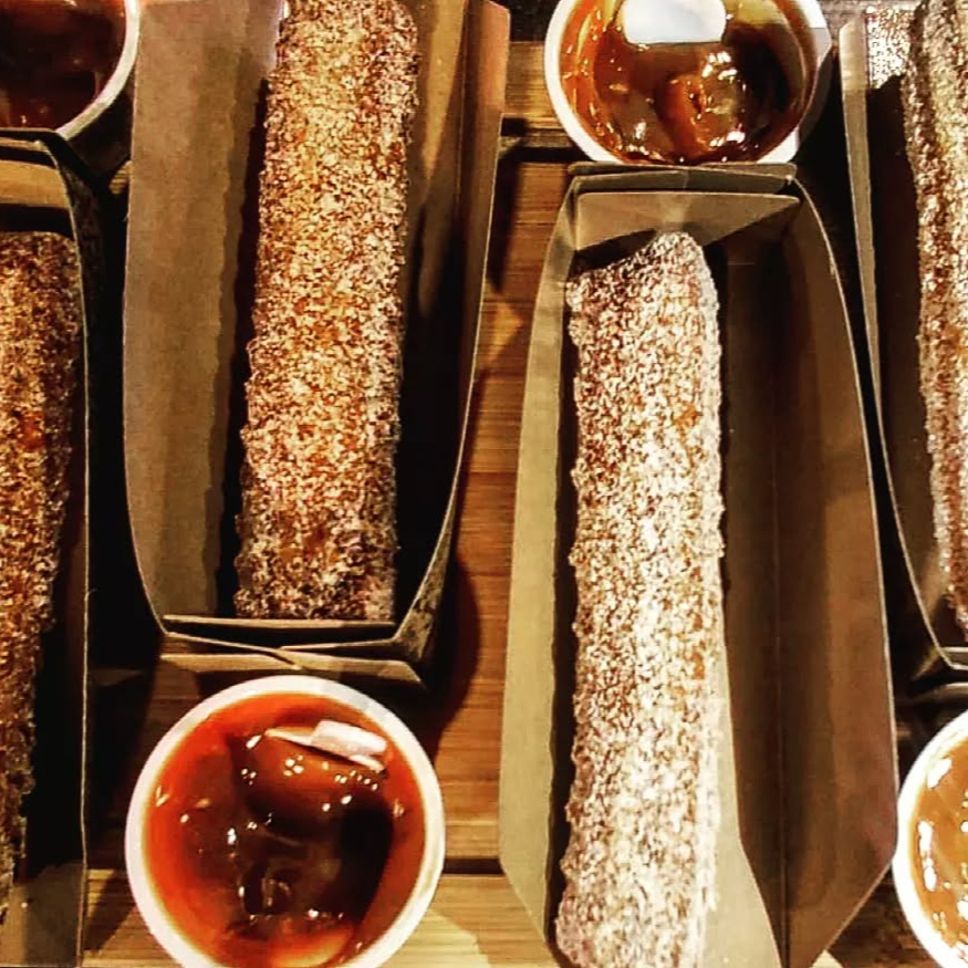 Uma unidade da deliciosa massa de churros tradicional polvilhado com açúcar e canela + aprox 60g de doce de leite embalado separadamente.