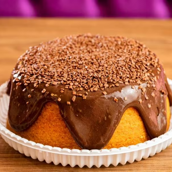 Massa: bolo de cenoura Recheio/Calda: calda de brigadeiro Cobertura/Decoração: salpicado com granulado Decoração adicional: dois brigadeiros