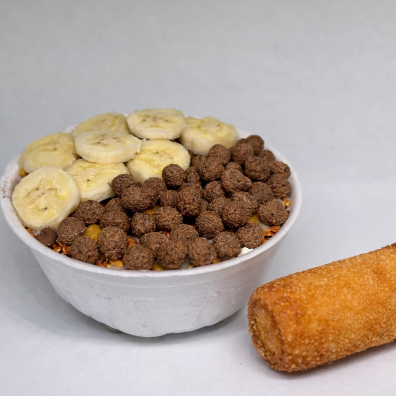 Vai acompanhado por 5 acompanhamentos, 2 opção de frutas, 1 opção de calda, junto com um enroladinho médio de cortesia.