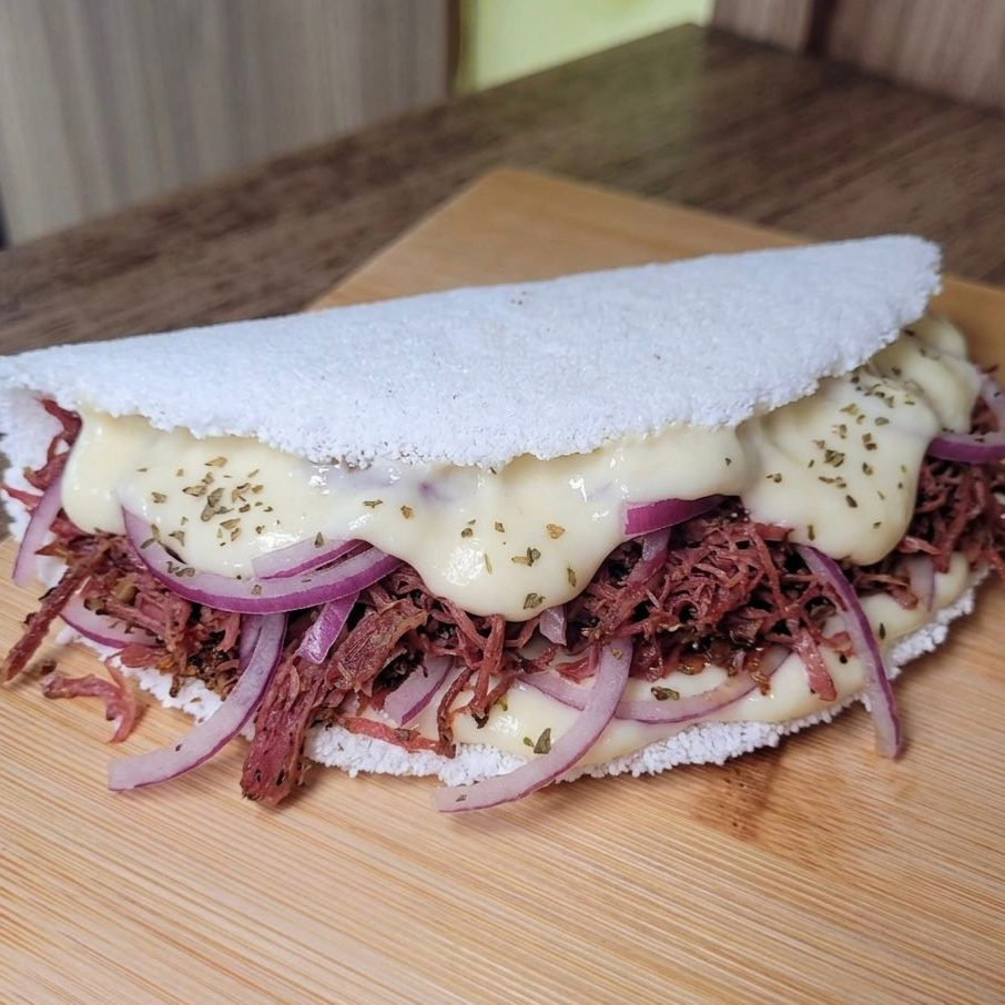 Goma de tapioca artesanal, carne seca desfiada e dessalgada ,requeijão cremoso, cebola roxa.
