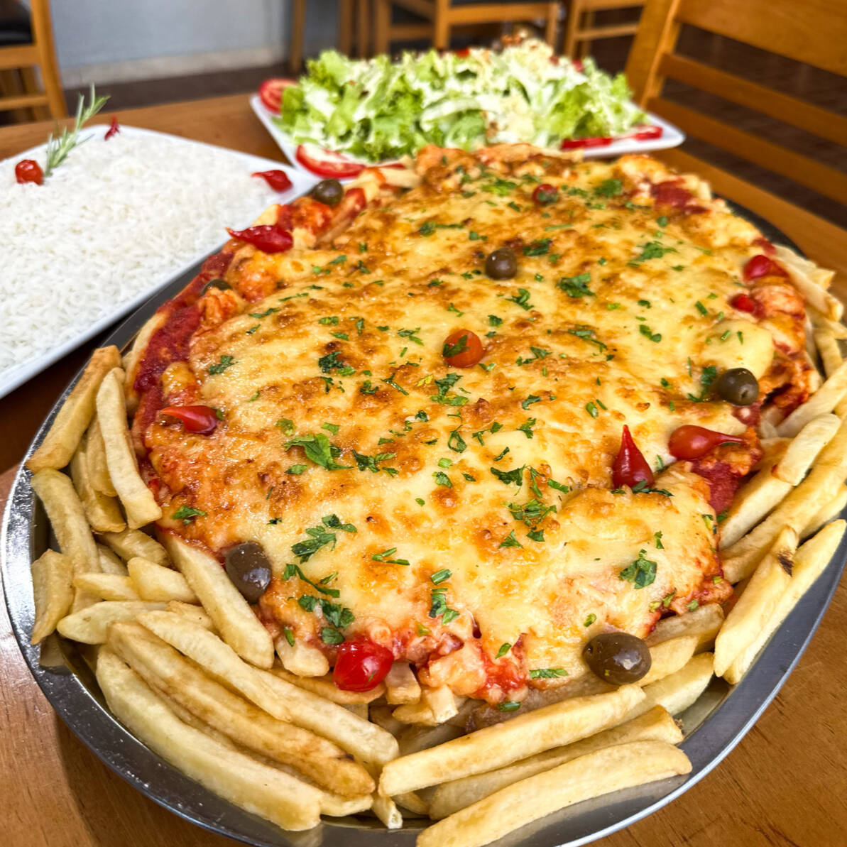 Frango com Catupiry servido ao Molho Vermelho Artesanal e mussarela e gratinado com parmessão. Servido com arroz branco, batatas fritas e salada do Cheff. Serve 5 pessoas
