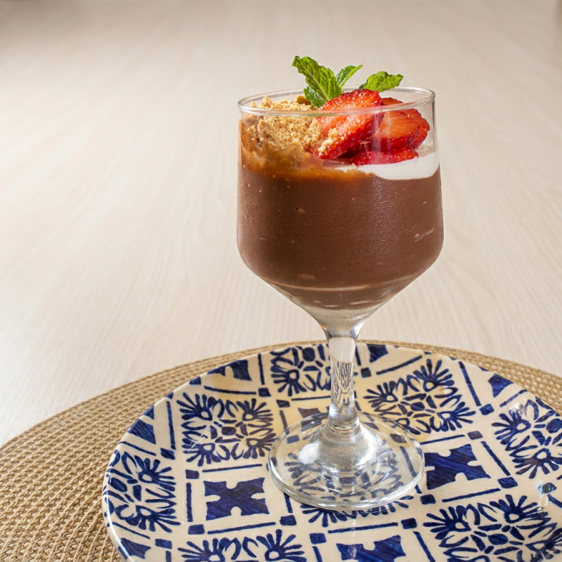 Servido com ganache de chocolate, morangos frescos e farofa de paçoca