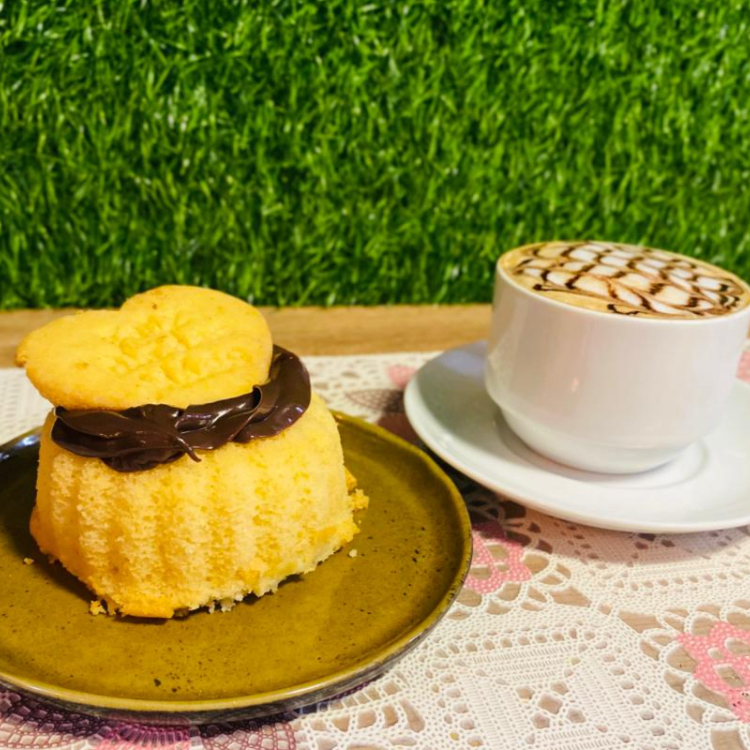 Mini bolo de baunilha com cobertura de chocolate e sequilho e café com leite