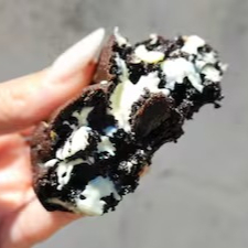 Cookie de cacau belga Black com gotas de chocolate branco. Intenso, delicioso e cheio de carinho em cada mordida!