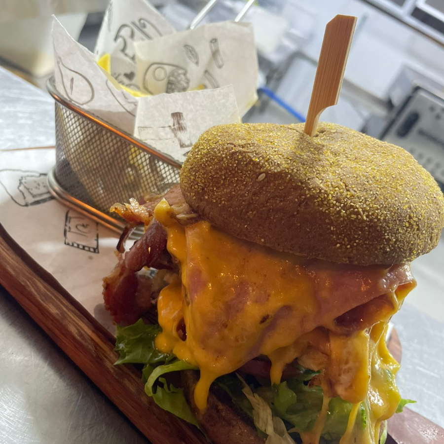 Pão Brioche, Hambúrguer Bovino 180g, 2 Fatias De Queijo Prato, 4 Fatias De Bacon, Creme De Cheddar e Molho Da Casa