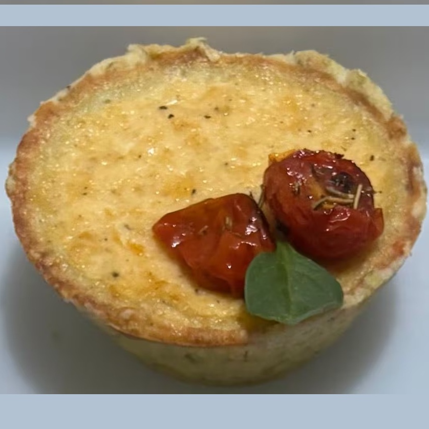Uma explosão de sabor em cada mordida! Nossa massa amanteigada, leve e delicadamente saborizada com manjericão fresco, desmancha na boca a cada pedaço. No recheio, a cremosidade irresistível da combinação perfeita de 3 queijos, equilibrada pelo toque sofisticado do confit de tomate cereja lentamente preparado para realçar sua doçura natural e levemente apimentado.
Uma empada intensa, aromática e apaixonante — impossível comer uma só.